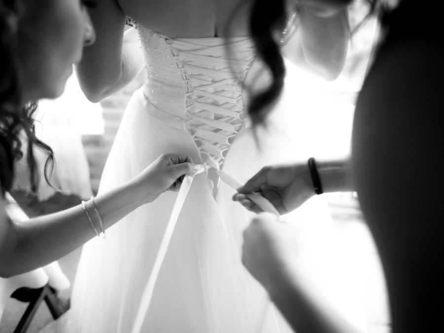 retouche d'une robe de marié pendant la cérémonie